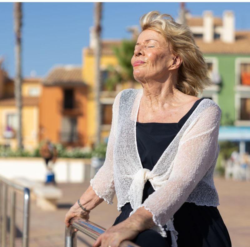Jessica Larive met gesloten ogen in de zon aan een Spaanse boulevard